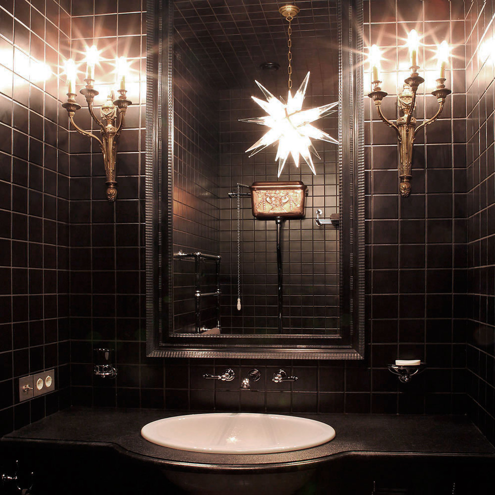 ロンドンにあるラグジュアリーなトラディショナルスタイルのおしゃれなトイレ・洗面所 (黒いタイル、黒い壁、オーバーカウンターシンク) の写真