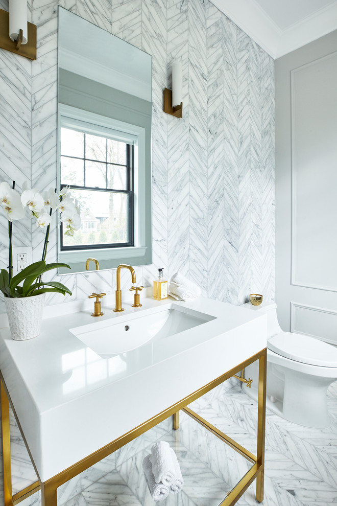 ニューヨークにある高級な小さなトランジショナルスタイルのおしゃれなトイレ・洗面所 (グレーのタイル、大理石タイル、グレーの壁、コンソール型シンク、白い洗面カウンター) の写真