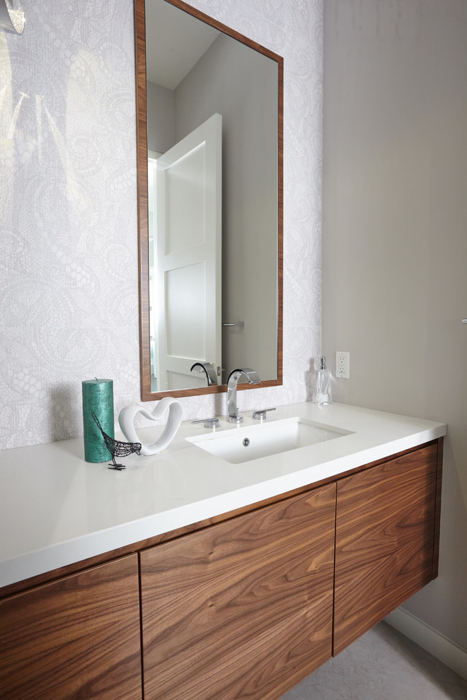 Foto di un bagno di servizio moderno di medie dimensioni con ante lisce, ante in legno scuro, pareti grigie, lavabo sottopiano, pavimento grigio e top bianco