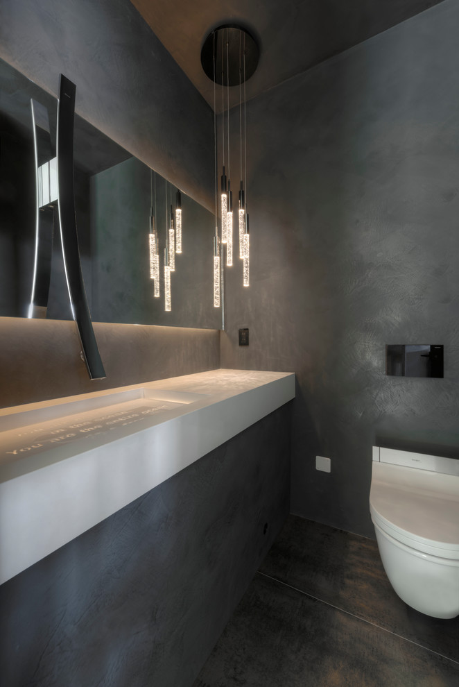 Inspiration pour un WC suspendu design de taille moyenne avec un carrelage gris, des carreaux de céramique, un mur gris, un sol en carrelage de céramique, un lavabo suspendu, un sol gris et un plan de toilette blanc.