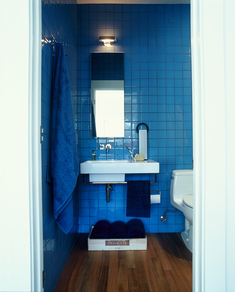 Ejemplo de aseo minimalista con lavabo suspendido, sanitario de una pieza, baldosas y/o azulejos azules y baldosas y/o azulejos de vidrio