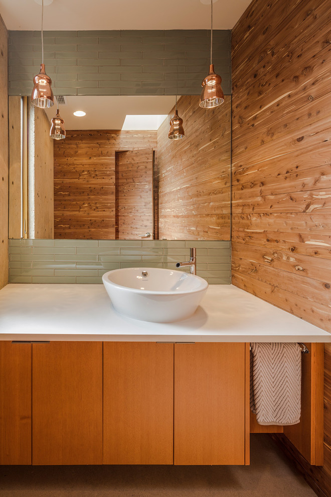 Réalisation d'un WC suspendu design en bois brun avec un placard à porte plane, un carrelage vert, un carrelage en pâte de verre, sol en béton ciré, une vasque et un plan de toilette en quartz modifié.