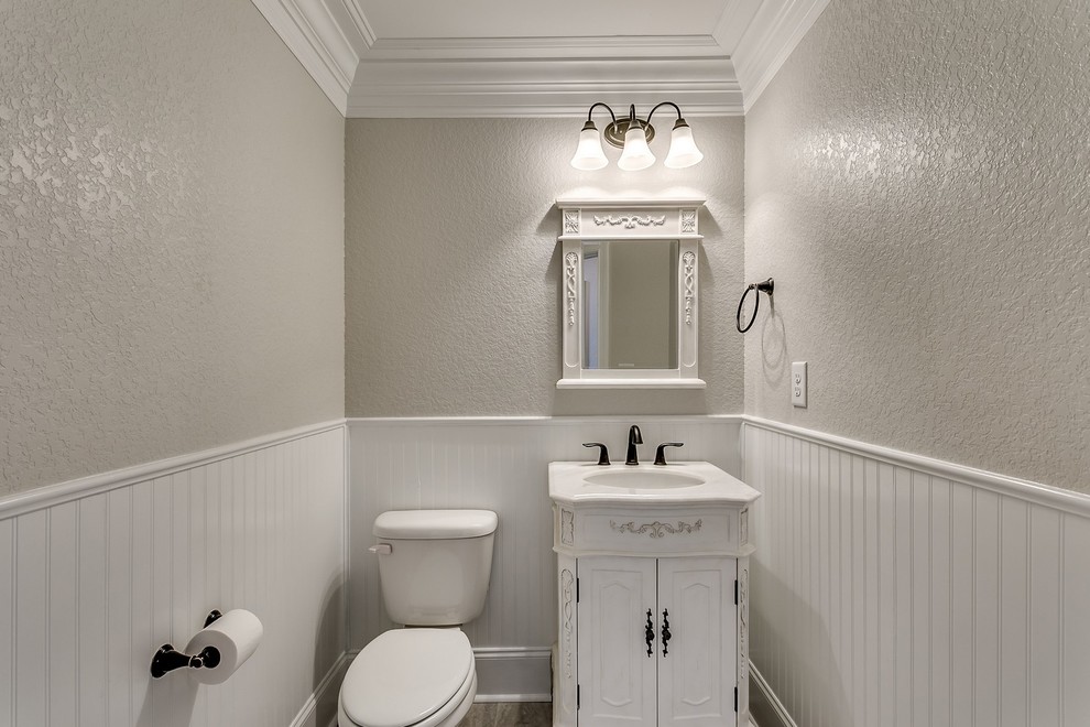 他の地域にある高級な中くらいなトラディショナルスタイルのおしゃれなトイレ・洗面所 (家具調キャビネット、黄色いキャビネット、磁器タイルの床、御影石の洗面台) の写真