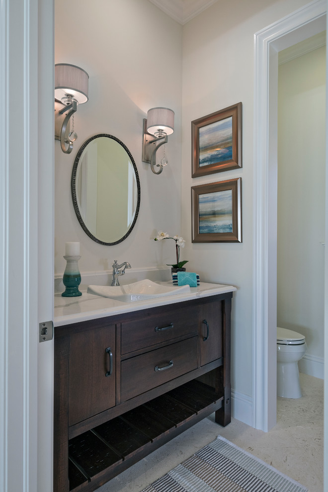 Photo of a small classic cloakroom in Miami with freestanding cabinets, dark wood cabinets, beige walls, a built-in sink and white worktops.