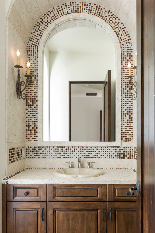Ispirazione per un bagno di servizio mediterraneo con lavabo da incasso, ante con bugna sagomata, ante in legno bruno, piastrelle multicolore, piastrelle a mosaico, pareti bianche e top bianco