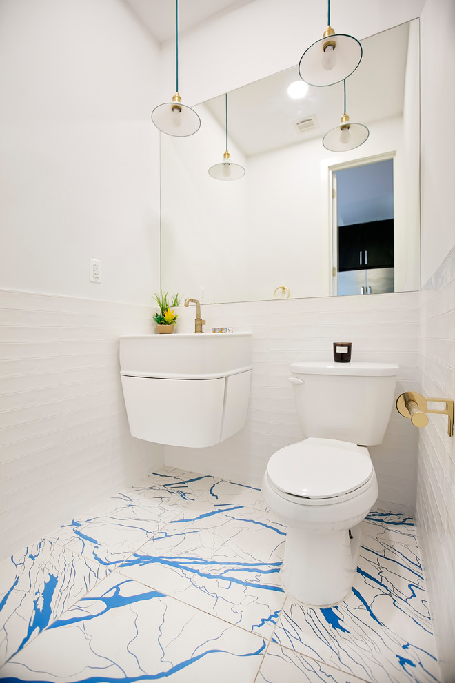 Стильный дизайн: маленький туалет в стиле модернизм с белыми фасадами, унитазом-моноблоком, керамогранитной плиткой, белыми стенами, подвесной раковиной, синим полом, полом из цементной плитки и белой плиткой для на участке и в саду - последний тренд