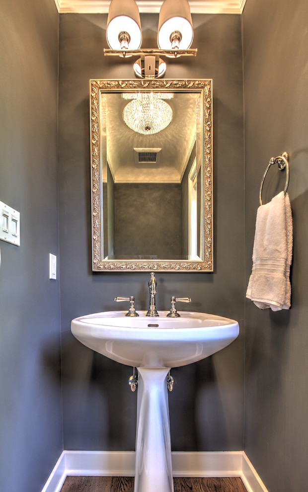Small elegant medium tone wood floor powder room photo in Seattle with a pedestal sink and gray walls