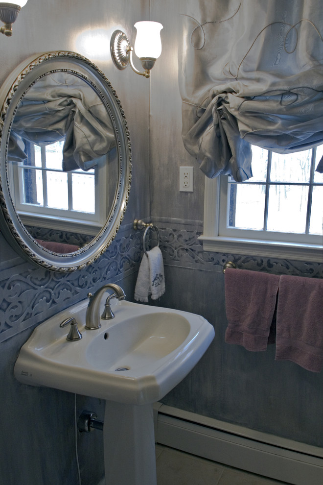 Inredning av ett klassiskt litet toalett, med ett piedestal handfat, en toalettstol med separat cisternkåpa, beige kakel, porslinskakel, blå väggar och klinkergolv i porslin