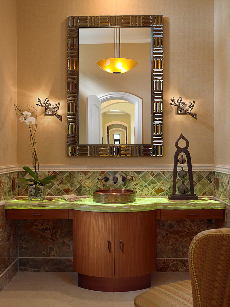 Immagine di un bagno di servizio mediterraneo con lavabo a bacinella, ante lisce, ante in legno scuro, top in vetro, piastrelle multicolore, piastrelle in pietra, pareti beige, pavimento in marmo e top verde