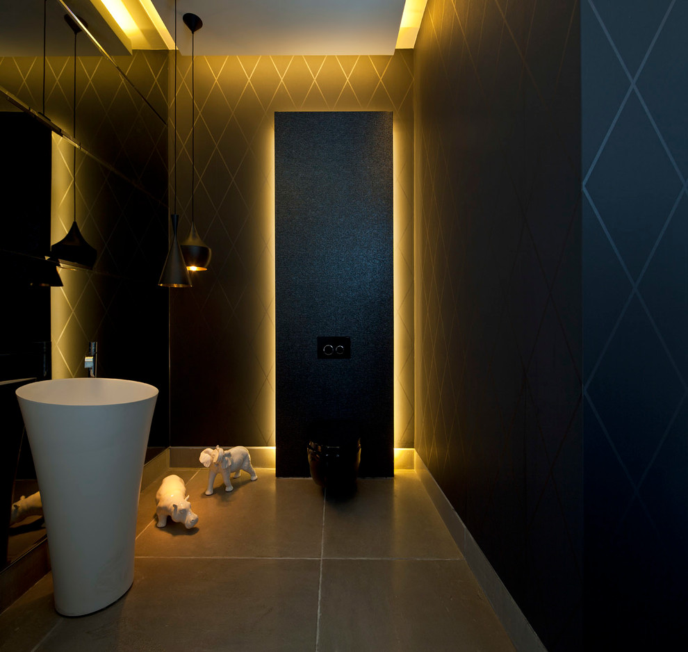 Immagine di un grande bagno di servizio moderno con lavabo a bacinella, WC sospeso, pareti nere e pavimento in pietra calcarea
