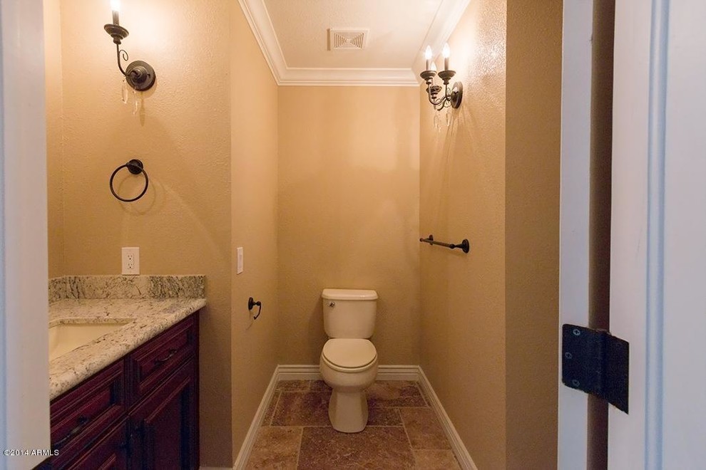 Cette photo montre un WC et toilettes victorien en bois foncé de taille moyenne avec un placard avec porte à panneau surélevé, WC séparés, un mur marron, un sol en travertin, un lavabo encastré, un plan de toilette en granite, un sol marron et un plan de toilette gris.