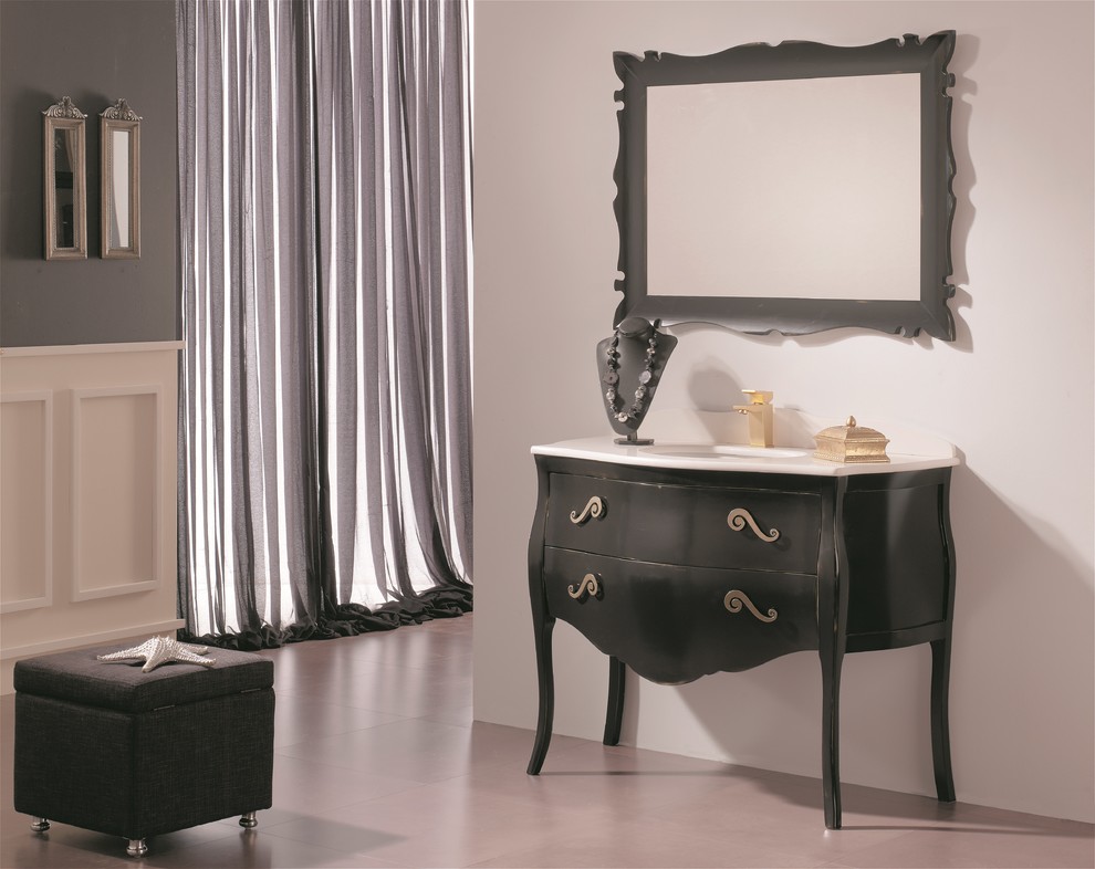 Inredning av ett klassiskt toalett, med ett undermonterad handfat, möbel-liknande, svarta skåp och marmorbänkskiva