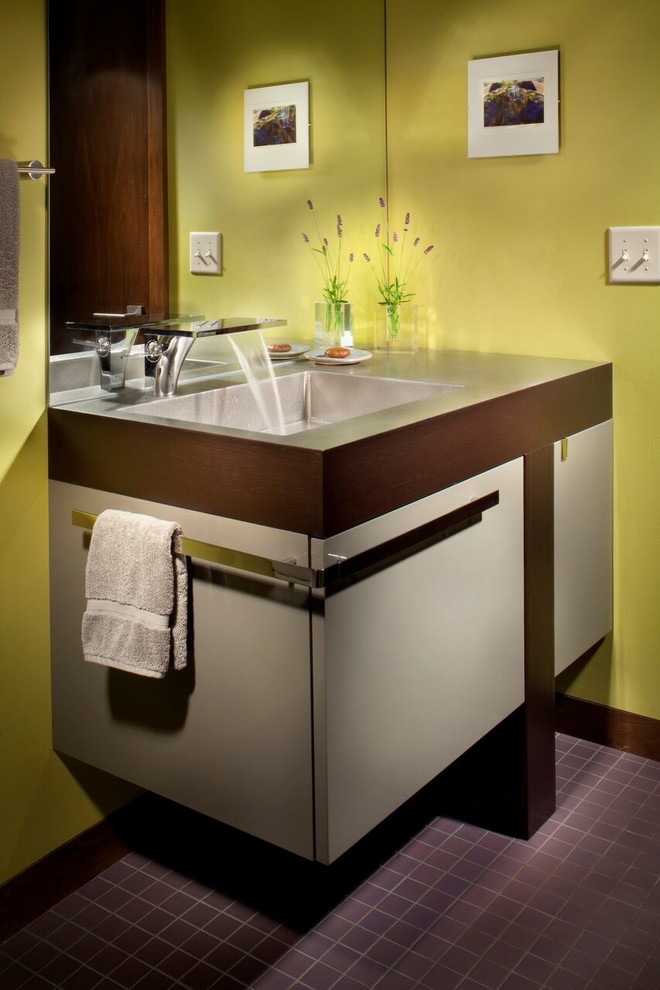 Kleine Moderne Gästetoilette mit flächenbündigen Schrankfronten, grauen Schränken, grüner Wandfarbe, Keramikboden, integriertem Waschbecken und Waschtisch aus Holz in Sonstige