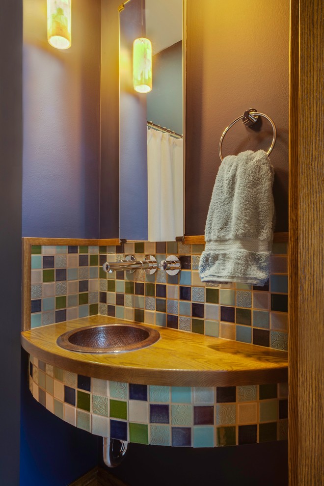 Пример оригинального дизайна: маленький туалет в стиле фьюжн с разноцветной плиткой, керамической плиткой, фиолетовыми стенами, накладной раковиной и столешницей из дерева для на участке и в саду
