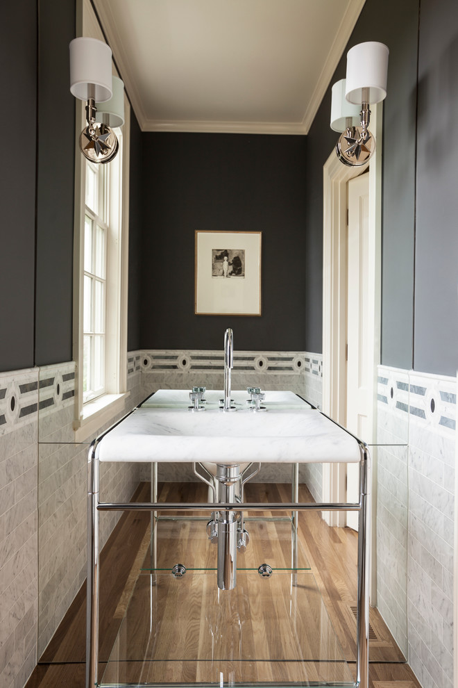 Example of a classic gray tile medium tone wood floor powder room design in Seattle with gray walls and a console sink