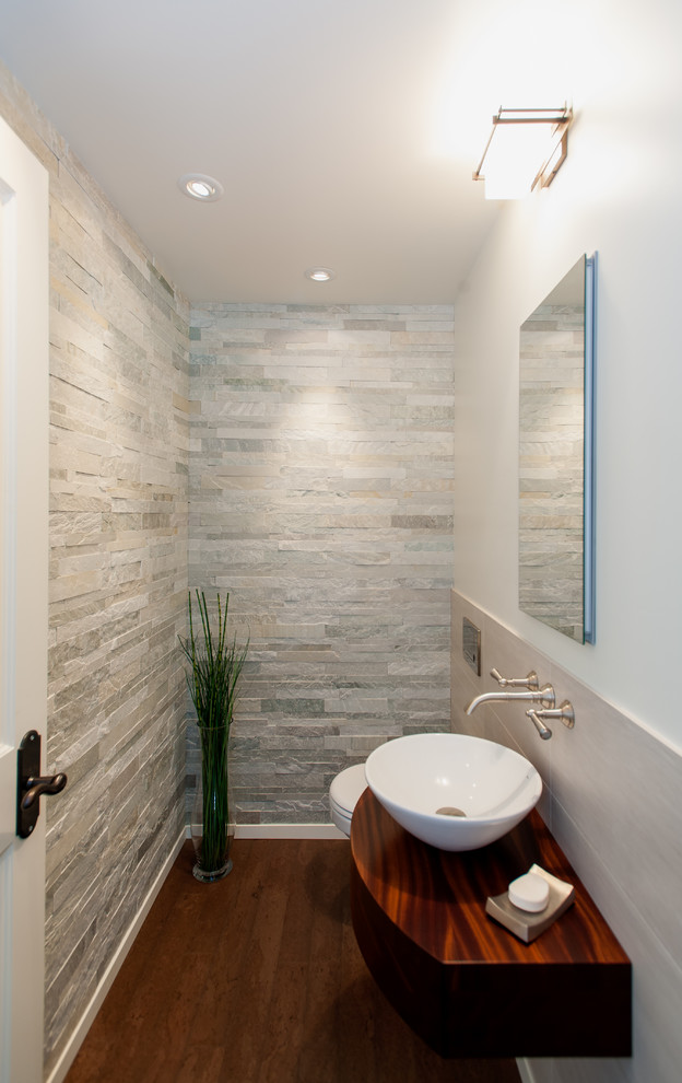Small classic cloakroom in Seattle with a wall mounted toilet, stone tiles, white walls, cork flooring, a vessel sink and grey tiles.