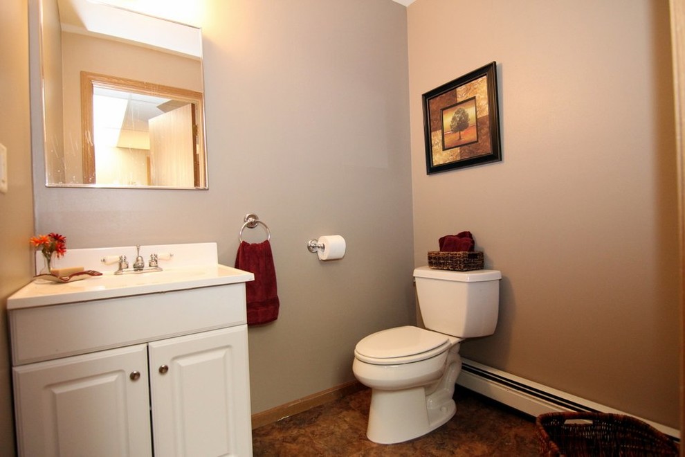 Inspiration för små klassiska toaletter, med luckor med upphöjd panel, vita skåp, en toalettstol med separat cisternkåpa, beige väggar, ett integrerad handfat och laminatbänkskiva