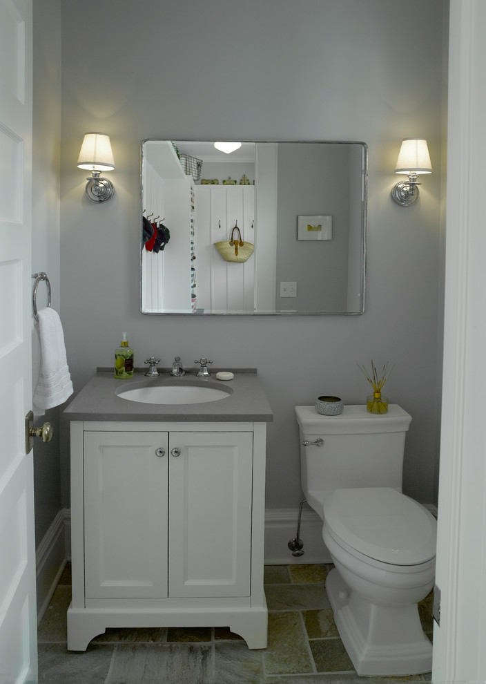 Exempel på ett litet klassiskt toalett, med släta luckor, vita skåp, en toalettstol med hel cisternkåpa, grå kakel, grå väggar, skiffergolv, ett undermonterad handfat och bänkskiva i kvarts