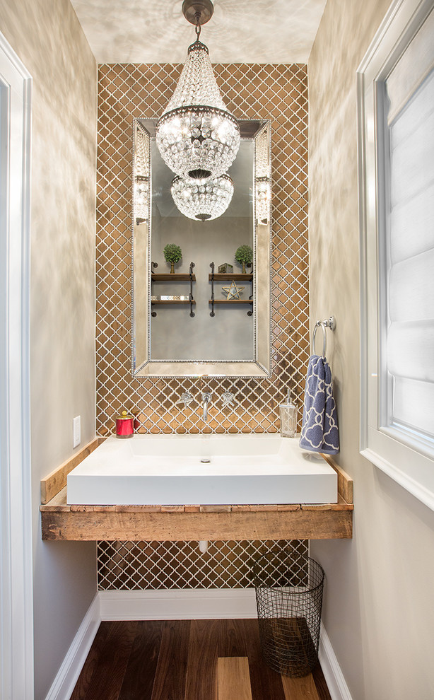 Inspiration for a transitional medium tone wood floor powder room remodel in Columbus with beige walls, a vessel sink, wood countertops and brown countertops