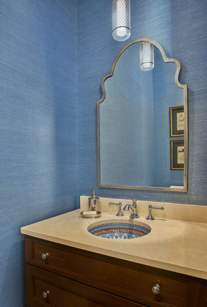 Idee per un bagno di servizio mediterraneo con ante con riquadro incassato, pareti blu, lavabo sottopiano e ante in legno bruno