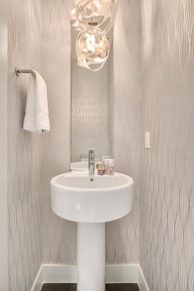 Idéer för ett litet modernt toalett, med beige väggar, mörkt trägolv, ett piedestal handfat och brunt golv