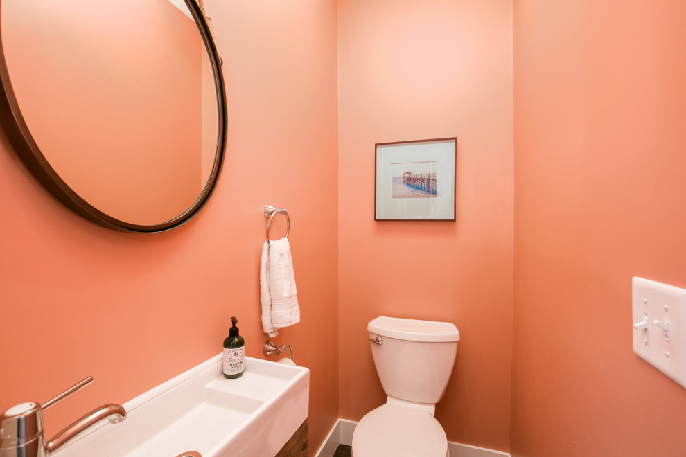 На фото: маленький туалет в стиле кантри с раздельным унитазом, оранжевыми стенами, темным паркетным полом, подвесной раковиной и коричневым полом для на участке и в саду с