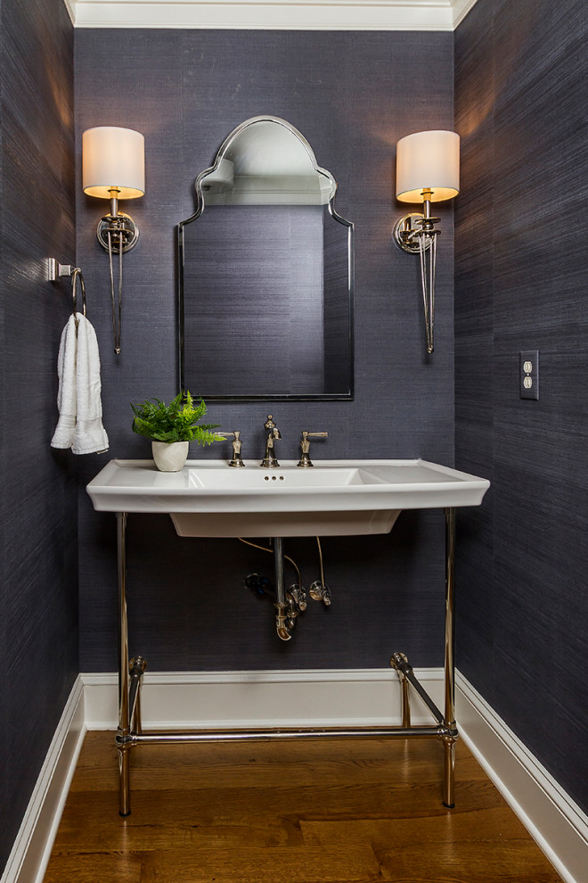 Exempel på ett mellanstort klassiskt toalett, med blå väggar, mellanmörkt trägolv, ett konsol handfat och brunt golv