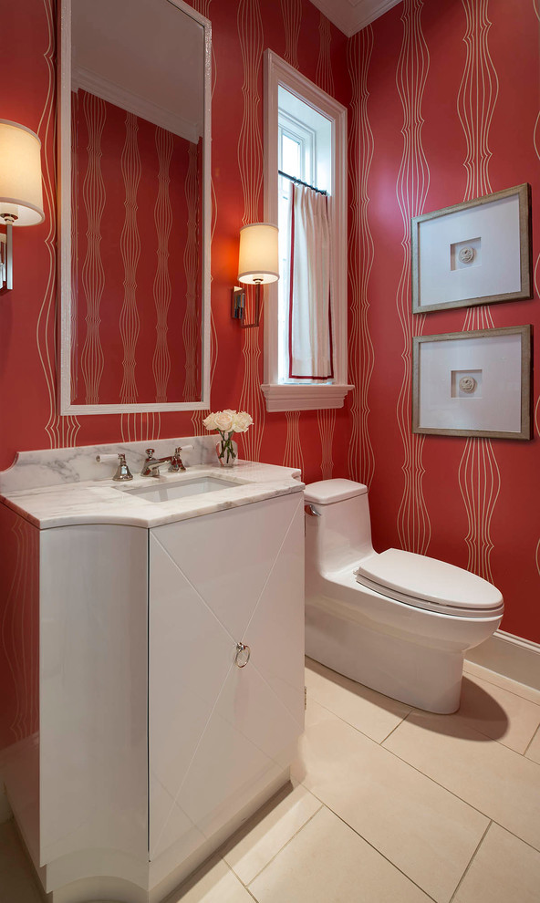 ダラスにあるトランジショナルスタイルのおしゃれなトイレ・洗面所 (アンダーカウンター洗面器、フラットパネル扉のキャビネット、白いキャビネット、大理石の洗面台、ベージュのタイル、赤い壁、一体型トイレ	) の写真