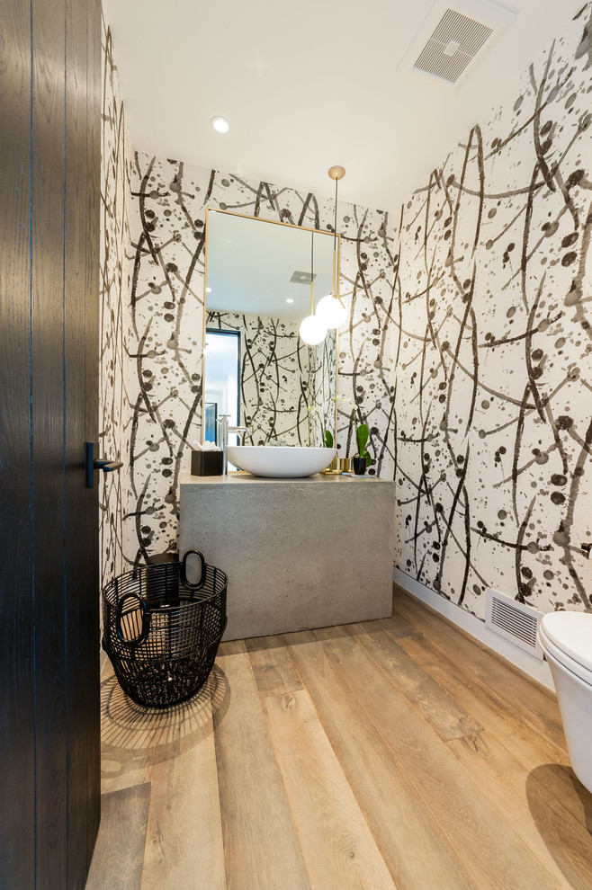 Kleine Moderne Gästetoilette mit Beton-Waschbecken/Waschtisch, Toilette mit Aufsatzspülkasten, bunten Wänden, Aufsatzwaschbecken und braunem Holzboden in Los Angeles
