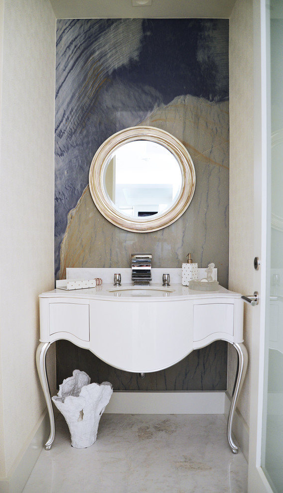 Inredning av ett klassiskt toalett, med ett undermonterad handfat, möbel-liknande, flerfärgade väggar, marmorgolv och vita skåp