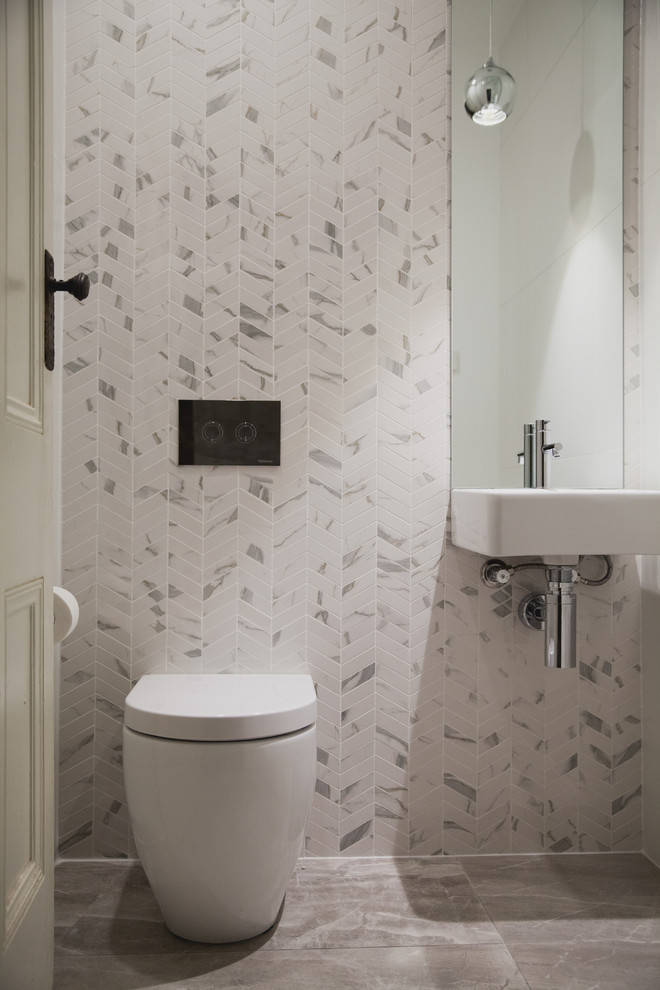 Cette image montre un WC et toilettes design avec un mur blanc, un lavabo suspendu, un sol gris et du carrelage en marbre.