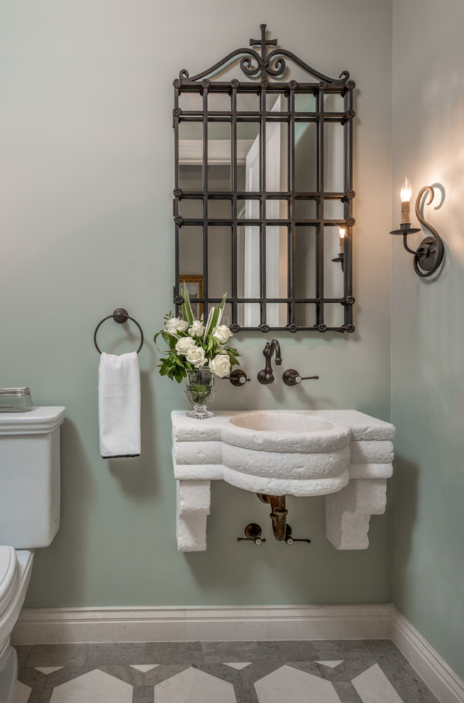 Geräumige Klassische Gästetoilette mit Kalkstein-Waschbecken/Waschtisch, Wandtoilette mit Spülkasten, grüner Wandfarbe, Kalkstein und Wandwaschbecken in Tampa