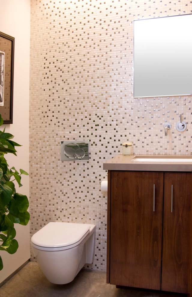 Inspiration for a mid-sized modern beige tile and mosaic tile concrete floor powder room remodel in Los Angeles with flat-panel cabinets, dark wood cabinets, a wall-mount toilet, beige walls, a vessel sink and quartz countertops