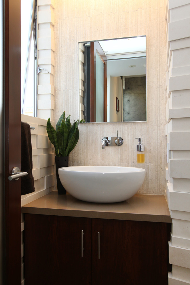 Design ideas for a medium sized modern cloakroom in Los Angeles with a vessel sink, recessed-panel cabinets, beige walls, dark wood cabinets, beige tiles, travertine tiles, engineered stone worktops and brown worktops.