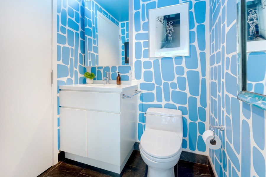 На фото: туалет в современном стиле с плоскими фасадами, белыми фасадами, унитазом-моноблоком, синими стенами, полом из керамической плитки, врезной раковиной и столешницей из искусственного кварца с