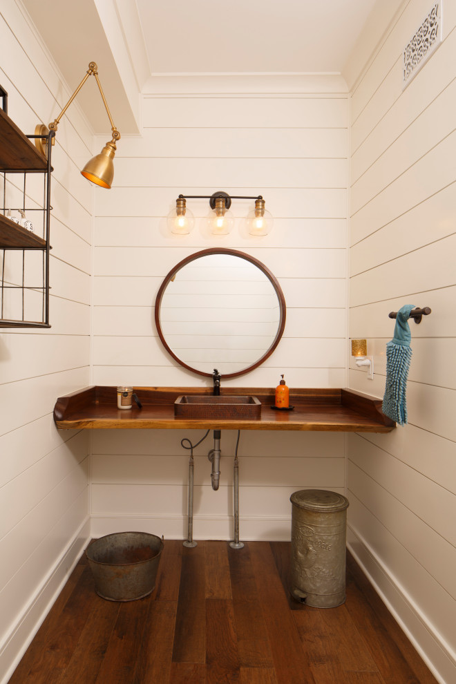 Aménagement d'un WC et toilettes campagne avec un mur blanc, parquet foncé, une vasque, un plan de toilette en bois, un sol marron, un plan de toilette marron et du lambris de bois.