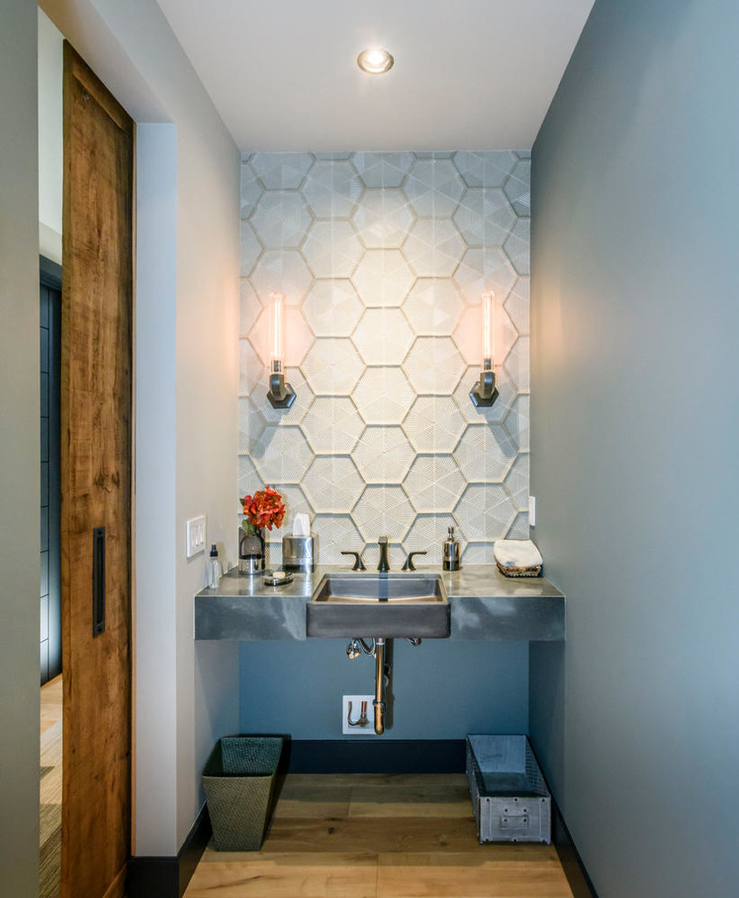 サンフランシスコにある小さなインダストリアルスタイルのおしゃれなトイレ・洗面所 (白いタイル、グレーの壁、淡色無垢フローリング、アンダーカウンター洗面器、グレーの洗面カウンター) の写真