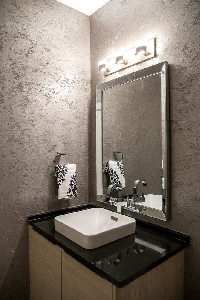 Idée de décoration pour un petit WC et toilettes minimaliste en bois clair avec un placard à porte plane, WC séparés, un carrelage gris, un mur gris, un sol en carrelage de porcelaine, une vasque et un plan de toilette en granite.