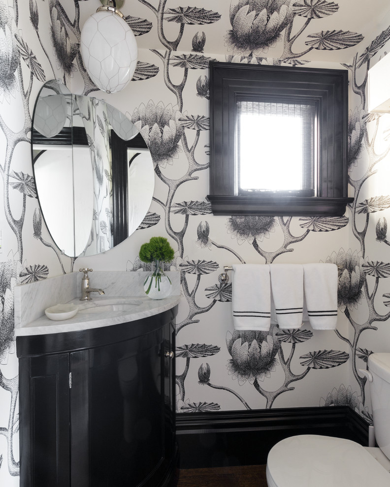 Пример оригинального дизайна: большой туалет в стиле фьюжн с фасадами с утопленной филенкой, черными фасадами, раздельным унитазом, врезной раковиной, мраморной столешницей и белой столешницей