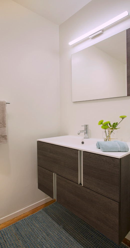Inspiration for a medium sized contemporary cloakroom in San Francisco with flat-panel cabinets, brown cabinets, white walls, light hardwood flooring, an integrated sink, engineered stone worktops, brown floors and white worktops.