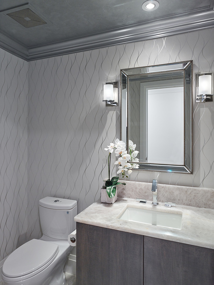 Mid-sized trendy powder room photo in Other with shaker cabinets, brown cabinets, a one-piece toilet, white walls, an undermount sink and beige countertops