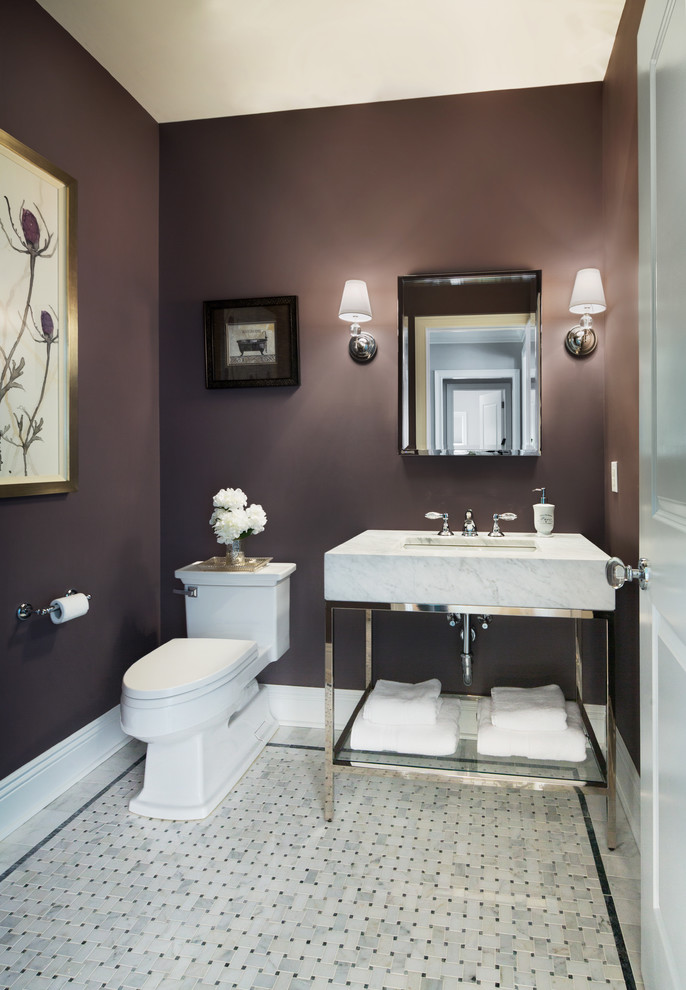 Cette image montre un WC et toilettes traditionnel de taille moyenne avec WC séparés, un plan de toilette en marbre, un mur violet, un sol en marbre et un lavabo encastré.