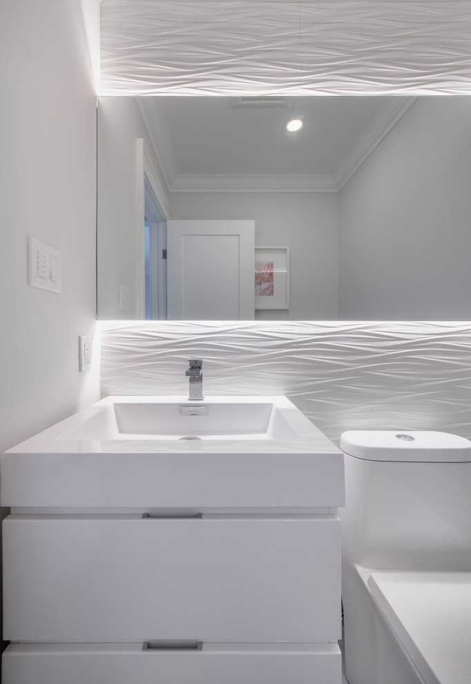 Свежая идея для дизайна: туалет среднего размера в стиле модернизм с плоскими фасадами, белыми фасадами, унитазом-моноблоком, белой плиткой, керамической плиткой, серыми стенами, полом из сланца, монолитной раковиной, столешницей из искусственного кварца, серым полом и белой столешницей - отличное фото интерьера