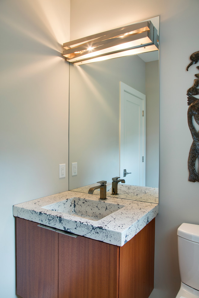 Esempio di un piccolo bagno di servizio minimal con ante lisce, ante in legno scuro, pareti grigie, lavabo integrato e top in cemento
