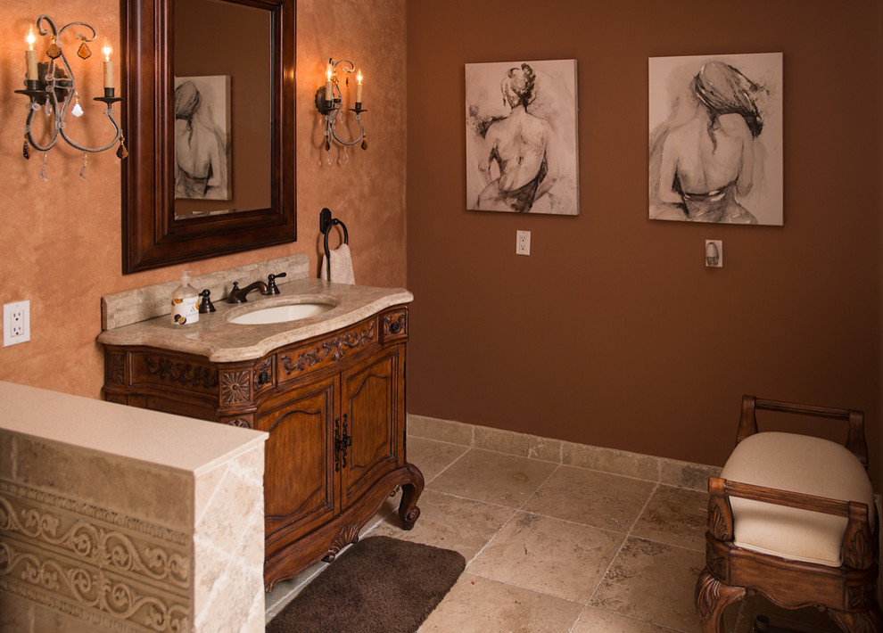 Foto di un piccolo bagno di servizio tradizionale con ante con riquadro incassato, ante in legno bruno, pareti beige, pavimento in travertino, lavabo sottopiano, top in marmo e pavimento beige
