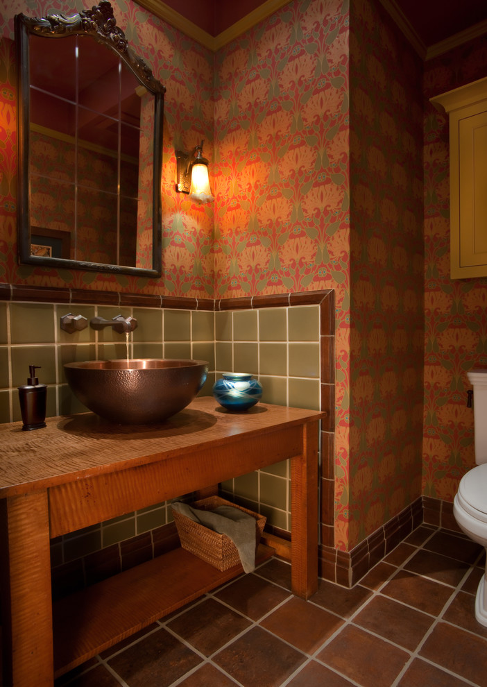 Inspiration for a small classic cloakroom in San Diego with open cabinets, medium wood cabinets, a two-piece toilet, red tiles, ceramic tiles, red walls, travertine flooring, a vessel sink, wooden worktops, brown floors and brown worktops.