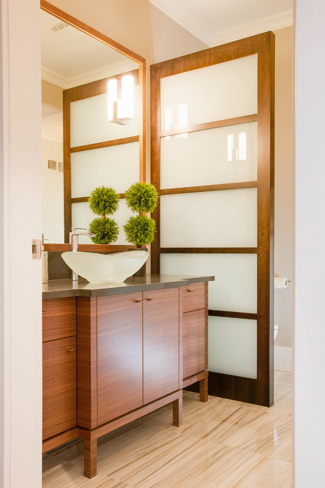 Идея дизайна: туалет в современном стиле с настольной раковиной, плоскими фасадами и фасадами цвета дерева среднего тона