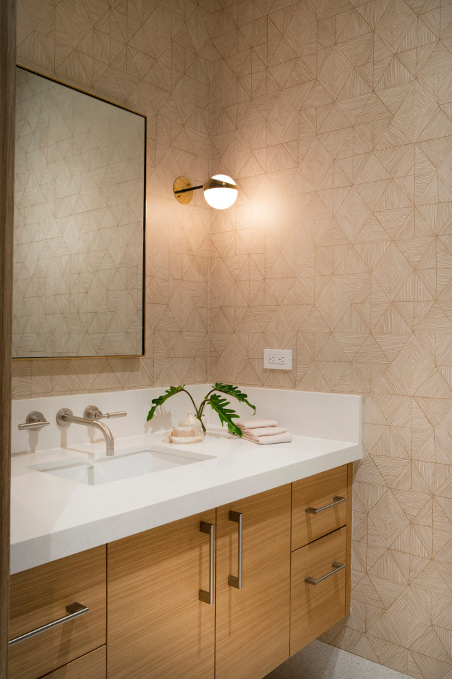 This is an example of a world-inspired cloakroom in Los Angeles with flat-panel cabinets, medium wood cabinets, beige walls, a submerged sink, white floors, white worktops, a floating vanity unit and wallpapered walls.