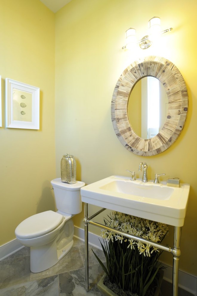 Beach style vinyl floor and gray floor powder room photo in Columbus with a two-piece toilet, yellow walls, a console sink and a freestanding vanity