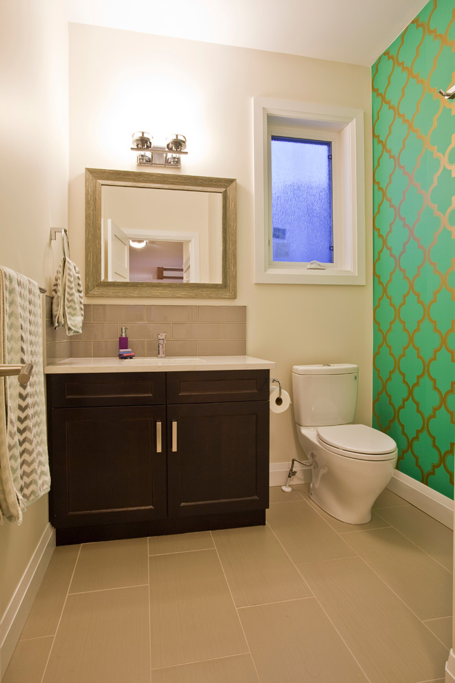 Exemple d'un WC et toilettes tendance en bois foncé de taille moyenne avec un lavabo encastré, un placard à porte shaker, un plan de toilette en quartz modifié, WC à poser, un carrelage gris, des carreaux de porcelaine, un mur vert et un sol en carrelage de porcelaine.